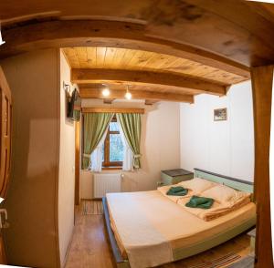 a bedroom with a large bed with a wooden ceiling at Pensiunea Vanatorul in Băile Tuşnad