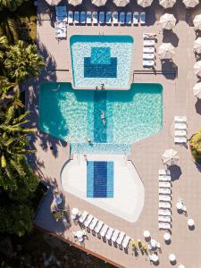 Plaza Caldas da Imperatriz Resort & Spa في سانتو أمارو دا إمبيراتريز: اطلالة علوية على مسبح مع كراسي ومظلات