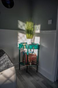 a green table with a plant on top of it at BV Classic 2 Bedroom At Leeds Road Huddersfield Perfect For Contractors in Huddersfield