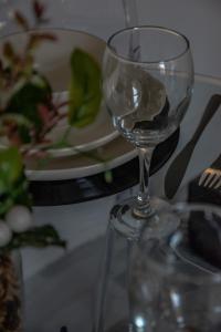 a wine glass sitting on a table with a plate of food at BV Classic 2 Bedroom At Leeds Road Huddersfield Perfect For Contractors in Huddersfield