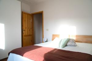 a bedroom with a large bed with a wooden door at Un Passo dal Cielo...Apartment in San Potito