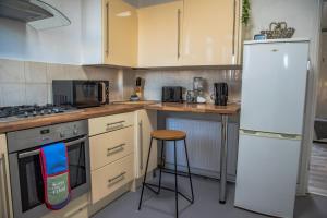 Il comprend une cuisine équipée d'une cuisinière et d'un réfrigérateur blanc. dans l'établissement BV Classic 2 Bedroom At Leeds Road Huddersfield Perfect For Contractors, à Huddersfield