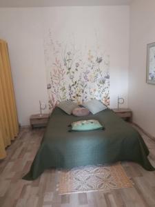 um quarto com uma cama com um cobertor verde em Gîte OZOO em Saint-Aignan