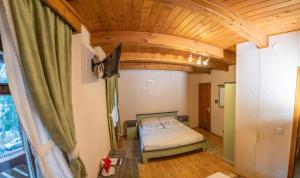 - une chambre avec un lit et un plafond en bois dans l'établissement Pensiunea Vanatorul, à Băile Tuşnad