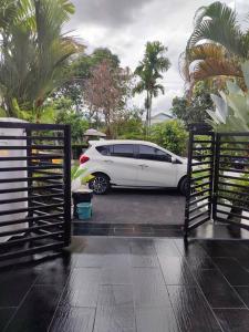 士毛月的住宿－Eqa's Homestay Perfect for Muslim family vacation，停车场内有棕榈树的白色汽车