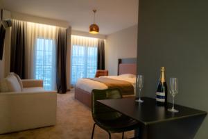 a hotel room with a bed and a table with a bottle of champagne at Downtown Apartments in Prishtinë