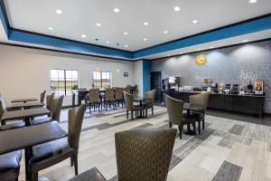 une salle à manger avec des tables et des chaises ainsi qu'une cafétéria dans l'établissement La Quinta by Wyndham Mt. Pleasant, à Mount Pleasant