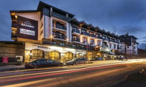 une rue avec des voitures garées devant un bâtiment dans l'établissement Hotel Bansko SPA & Holidays - Free Parking, à Bansko