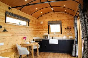 a kitchen in a log cabin with a sink and a table at Lily in Rhayader