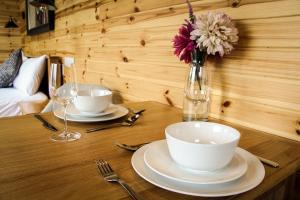 a wooden table with two plates and a vase with flowers at Lily in Rhayader +15 photos