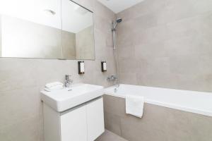 a white bathroom with a sink and a mirror at City Castle Apartments Free Parking in Bratislava