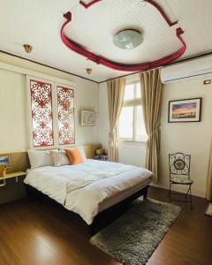 馬公市的住宿－澎湖姆居民宿，一间卧室设有一张红色天花板的大床
