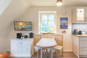 a kitchen with a table and chairs in a room at Lieblingsplatz in Sankt Peter-Ording