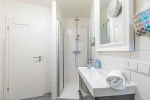 a white bathroom with a sink and a shower at Lieblingsplatz in Sankt Peter-Ording