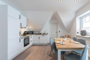 a kitchen and dining room with a wooden table and chairs at Langeneß in Hattstedt