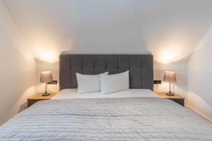 a bedroom with a large bed with two lamps at Langeneß in Hattstedt