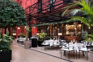 a restaurant with tables and chairs in a building at Los Seises Sevilla, a Tribute Portfolio Hotel in Seville