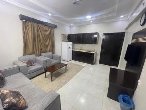 a living room with a couch and a table at Admire Apart Hotel - 1 in Abu Arish