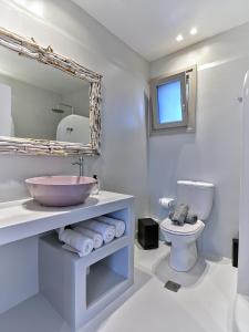 a bathroom with a sink and a toilet and a mirror at Empire Luxury Villas in Santa Maria