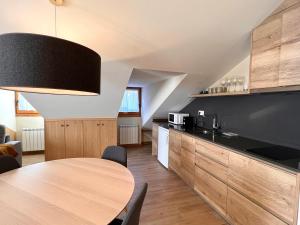 a kitchen with a wooden table in a room at Apartaments Areny - L'Amfitriona in Esterri d'Àneu