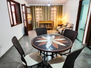 una sala da pranzo con tavolo e sedie di Aloha Casa em Ilhabela a Ilhabela