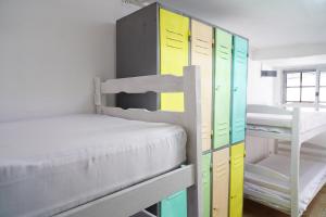 a bedroom with a bunk bed and colorful cabinets at Hué Hostel in Punta Del Diablo