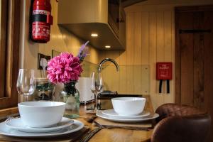 a table with plates and bowls and a vase of flowers at Poppy in Rhayader