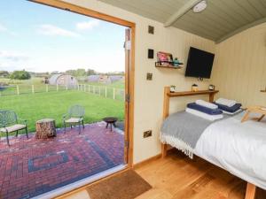 a bedroom with a bed and a large window at Poppy in Rhayader