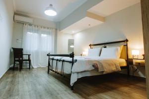 a bedroom with a bed and a table and a chair at Hermes Appartment in Chalkida