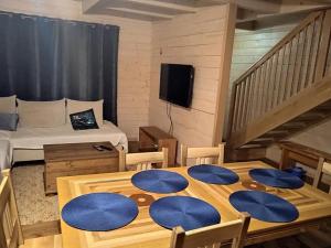 a room with a wooden table with blue cushions on it at Chata Adam je pre rodiny s deťmi terasa, detské ihrisko in Liptovský Mikuláš
