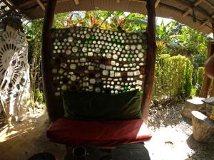 una silla bajo un techo con una almohada verde en Reciclarte Galería Hostal, en Capurganá