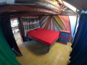 an overhead view of a red bed in a yurt at Reciclarte Galería Hostal in Capurganá