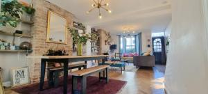 - un salon avec une table et un mur en briques dans l'établissement Eclectic seaside 4 bedroom artists residence, à Margate