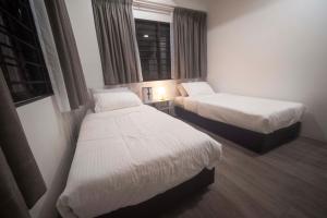 a room with two beds and a window at Genting View Resort GVR Kempas in Genting Highlands
