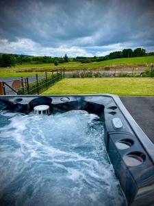 a jacuzzi tub with a table in the middle at Primrose in Rhayader