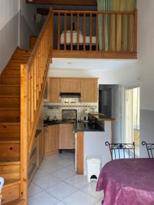 une cuisine avec des placards en bois et un escalier en bois dans l'établissement Les gites du pont de Reynes, à Reynès