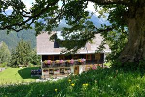 a house with a balcony with flowers on it at Selbstversorgerhaus Herisch in Schladming