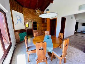 a dining room with a wooden table and chairs at Casa Ibañez in Villa Gesell