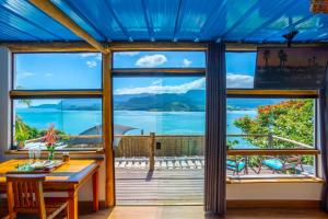 a dining room with a view of the ocean at Cobertura com Incrível Vista de Cinema para o Mar in Ilhabela