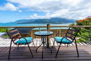 una mesa y sillas en una terraza con vistas al agua en Cobertura com Incrível Vista de Cinema para o Mar, en Ilhabela
