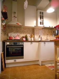 - une cuisine avec des placards blancs et une cuisinière dans l'établissement La casa azzurra, à Moneglia