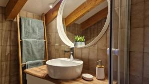 een badkamer met een wastafel en een spiegel bij Ferienwohnung-Kuschelzeit in Pfronten