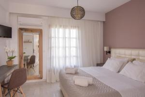 a bedroom with a large white bed and a table at The Wave in Sidari