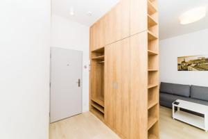 a large wooden cabinet in a living room with a couch at City Castle Apartments Free Parking in Bratislava