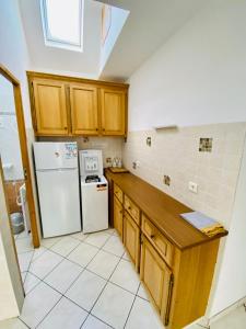 - une cuisine avec des placards en bois et un réfrigérateur blanc dans l'établissement Jolie maison bourg de Penvenan, à Penvénan