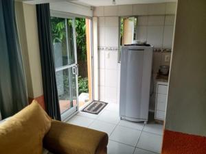 a kitchen with a refrigerator and a door to a yard at A Casa Laranja in Florianópolis