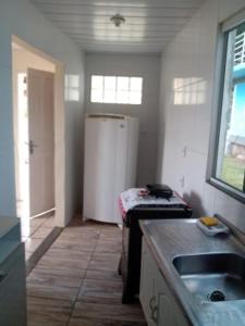 a kitchen with a refrigerator and a table in it at A Casa Laranja in Florianópolis