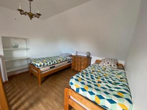 - une chambre avec 2 lits jumeaux et un lustre dans l'établissement Jolie maison bourg de Penvenan, à Penvénan