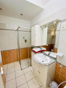 La salle de bains est pourvue d'un lavabo et d'une douche. dans l'établissement Jolie maison bourg de Penvenan, à Penvénan