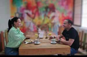 Ein Mann und eine Frau sitzen an einem Tisch in der Unterkunft Hotel Casa La Pilonera in Valledupar